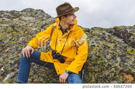 cheerful happy handsome hiker sitting on the big stones 68687260