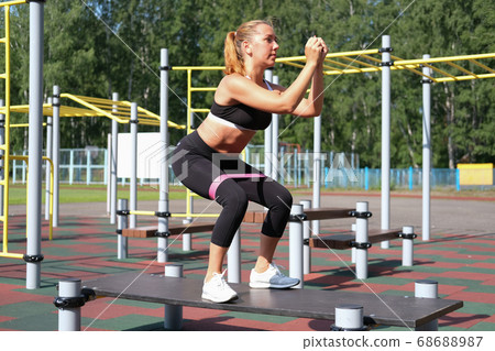 beautiful sporty woman doing squats with beautiful sporty woman doing squats with 68688987