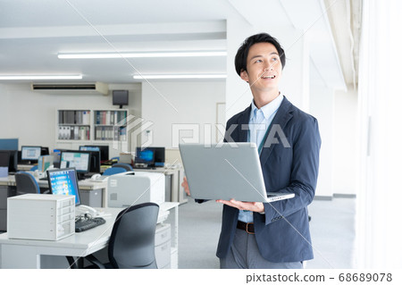 A young business man checking email by going to the office alone in the early morning 68689078