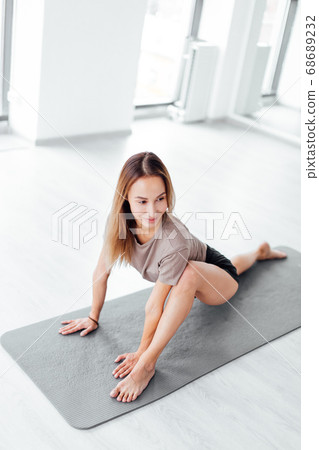 Side view of good looking smiling athlete dancing on the floor Side view of good looking smiling athlete dancing on the floor 68689232
