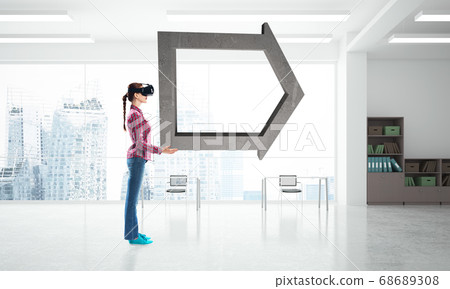 Girl in virtual reality mask experiencing virtual technology world. Mixed media 68689308