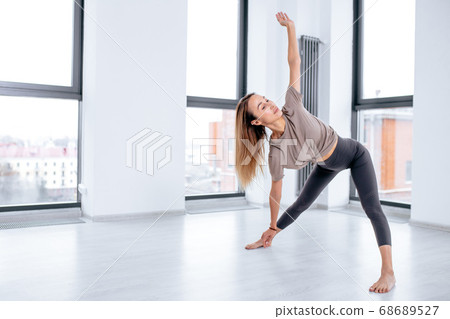 sweaaty woman concentrated on gymnastics in the fitness studio 68689527