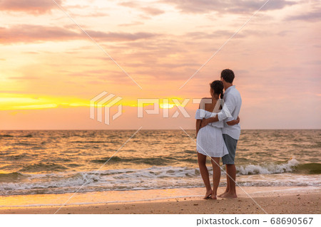 Honeymoon couple walking on sunset romantic stroll on Lover's key beach in Florida enjoying evening light relaxing on tropical summer vacation travel holiday. Two adults silhouettes lifestyle Honeymoon couple walking on sunset romantic stroll on Lover's key beach in Florida enjoying evening light relaxing on tropical summer vacation travel holiday. Two adults silhouettes lifestyle 68690567