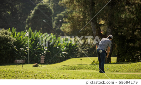 A person standing on top of a grass covered field 68694179