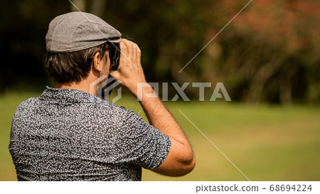 A person standing on top of a grass covered field 68694224