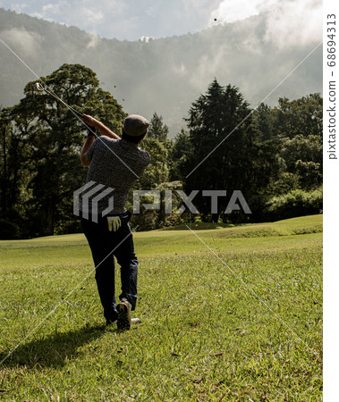 A person standing on top of a grass covered field 68694313