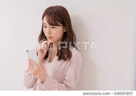 看智能手機的一個擔心的少婦 68695907