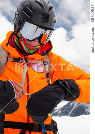 Portrait of a stern climber skier in sunglasses and a cap with a ski mask on his face. against the backdrop of Mount Elbrus 68700037