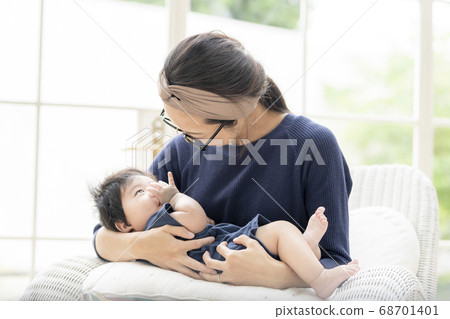 A mother holding a 5 month old baby 68701401