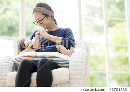 母親給一個五個月大的男孩牛奶 母親給一個五個月大的男孩牛奶 68701880