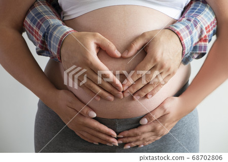 Close up shot of young man hugging his pregnant Close up shot of young man hugging his pregnant 68702806