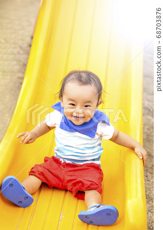 Boy looking happy on the slide in the park 68703876