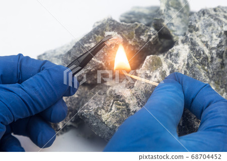 Asbestos fibers over a burning match. Asbestos fibers over a burning match. 68704452