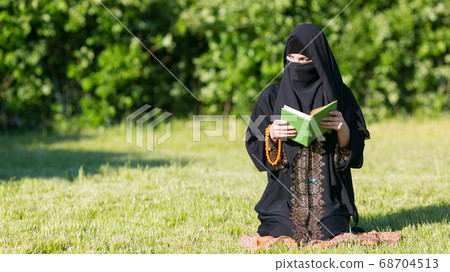 A woman from the East performs morning prayer 68704513