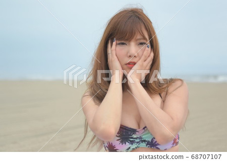 Swimsuit woman posing on the beach 68707107