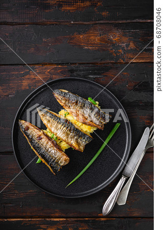 Roasted mackerel fish with garlic, paprika and saffronon dark wooden table, top view with copy space 68708046