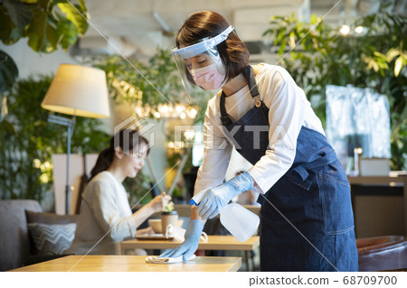 A restaurant clerk who disinfects 68709700