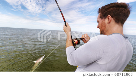 Shark fishing big game spinner shark biting bait man fisher reeling in animal in catch and release sports activity on water. Boat tour 68711903
