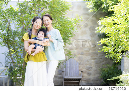Mother and grandmother holding a 5 month old baby 68714910