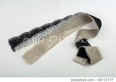 Lace on natural linen fabric. Lace on natural linen fabric. 68715777