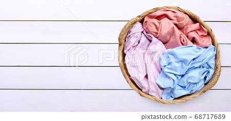 Colorful clothes in laundry basket on white wooden 68717689