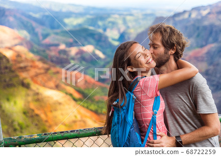 Couple in love kissing on nature travel hiking in Hawaii mountains. Young hikers people happy together. Interracial backpacking lovers kiss portrait on vacation hike Couple in love kissing on nature travel hiking in Hawaii mountains. Young hikers people happy together. Interracial backpacking lovers kiss portrait on vacation hike 68722259