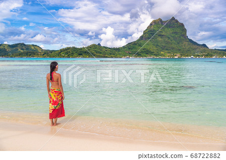 French polynesia tropical beach vacation backgrround. Bora bora island famous destination woman in Tahiti wearing polynesian skirt bathing in turquoise ocean. Paradise holiday French polynesia tropical beach vacation backgrround. Bora bora island famous destination woman in Tahiti wearing polynesian skirt bathing in turquoise ocean. Paradise holiday 68722882