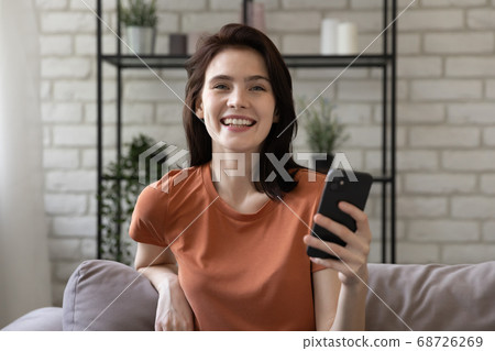 Headshot portrait of smiling millennial girl using cellphone 68726269
