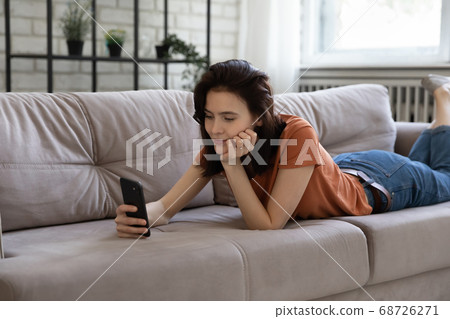 Caucasian woman relax on sofa using cellphone 68726271