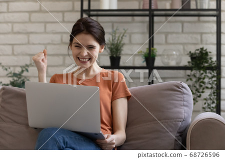 Happy millennial girl triumph winning online lottery Happy millennial girl triumph winning online lottery 68726596