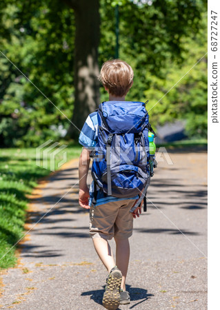 Boy hiking in the park with huge rucksack 68727247
