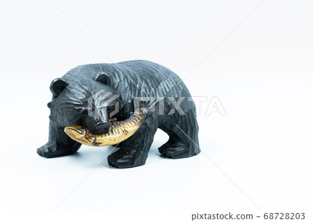 Wooden carved bear with salmon in his mouth, white background Wooden carved bear with salmon in his mouth, white background 68728203