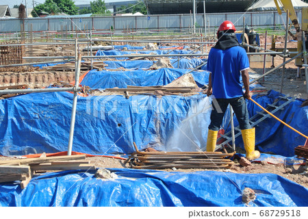 JOHOR, MALAYSIA -MARCH 29, 2016: Construction workers spraying the anti termite chemical treatment to the soil at the construction site. JOHOR, MALAYSIA -MARCH 29, 2016: Construction workers spraying the anti termite chemical treatment to the soil at the construction site. 68729518
