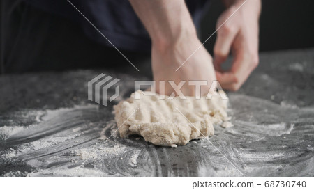 man working with dough on concrete countertop man working with dough on concrete countertop 68730740