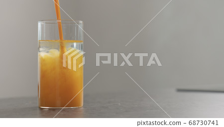 sea buckthorn juice pour into beaker glass with water on concrete surface 68730741