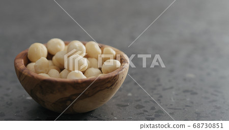 shelled macadamia nuts in olive wood bowl on terrazzo surface shelled macadamia nuts in olive wood bowl on terrazzo surface 68730851
