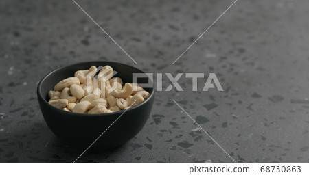 cashew nuts in black bowl on terrazzo countertop 68730863