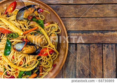 Top view of spicy spaghetti seafood on a wood Top view of spicy spaghetti seafood on a wood 68730869