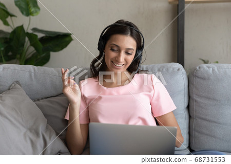 Smiling ethnic woman in headphones talk on webcam 68731553