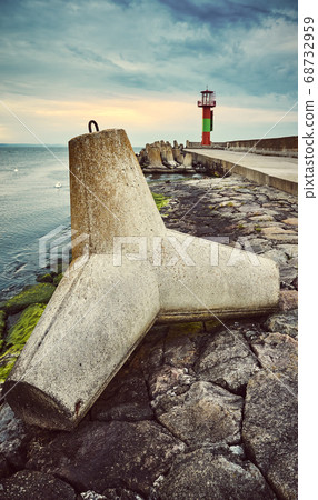 Concrete tetrapod breakwater on a pier at sunset. Concrete tetrapod breakwater on a pier at sunset. 68732959