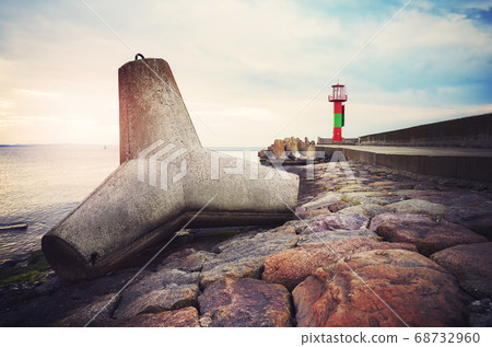 Concrete tetrapod breakwater on a pier at sunset. Concrete tetrapod breakwater on a pier at sunset. 68732960