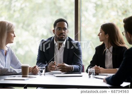 Troubled dark-skinned ceo informing staff about hard times in business Troubled dark-skinned ceo informing staff about hard times in business 68734563