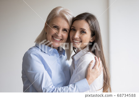 Happy senior mother embracing warmly her adult daughter Happy senior mother embracing warmly her adult daughter 68734588