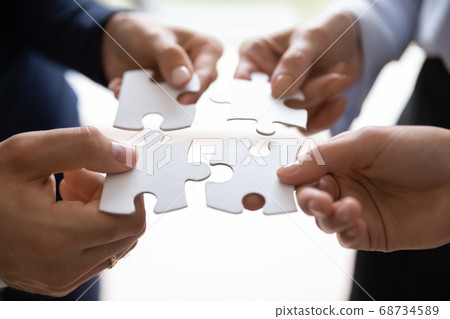 Diverse businesspeople collecting puzzle showing successful teamwork Diverse businesspeople collecting puzzle showing successful teamwork 68734589