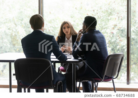 Diverse group of colleagues discussing project in office Diverse group of colleagues discussing project in office 68734688