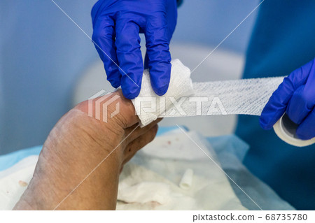 Healthcare worker nursing toe with bandage gauz Healthcare worker nursing toe with bandage gauz 68735780