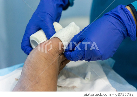 Healthcare worker nursing toe with bandage gauz 68735782