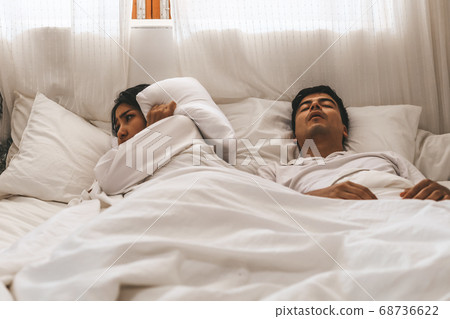 Wife can't sleep Because the husband snores loudly on bedroom in morning. Wife can't sleep Because the husband snores loudly on bedroom in morning. 68736622
