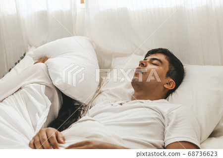Wife can't sleep Because the husband snores loudly on bedroom in morning. Wife can't sleep Because the husband snores loudly on bedroom in morning. 68736623