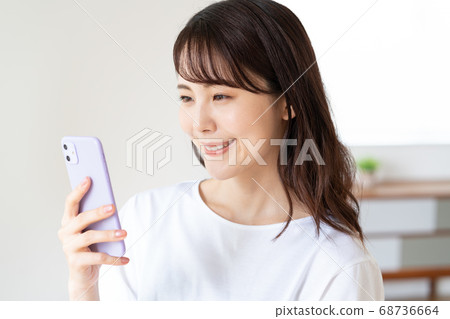 一個微笑的少婦的特寫鏡頭談話在與智能手機的徒升 一個微笑的少婦的特寫鏡頭談話在與智能手機的徒升 68736664